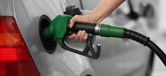 a person holding a gas pump in their car